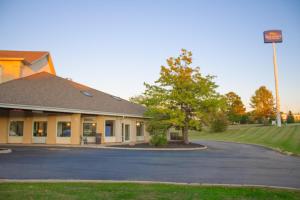 a building with a tree next to a street at Baymont by Wyndham Howell/Brighton in Howell