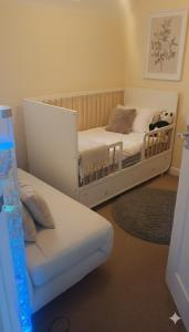 a bedroom with two twin beds and a couch at Modern Beautiful Luxury Coach House Free Parking in Birmingham