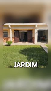 a building with a lawn in front of it at Casa Andar Térreo - Balneário Nordeste - Imbé - RS in Imbé