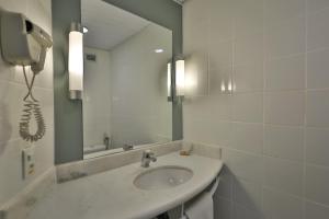 ein Badezimmer mit Waschbecken und Spiegel in der Unterkunft Ibis Salvador Rio Vermelho in Salvador