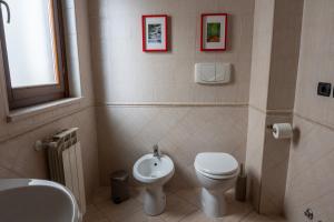 a bathroom with a white toilet and a sink at appartamento con terrazzo vicino all'aeroporto di Fiumicino e alla fiera di Roma in Fiumicino Airport +11 photos