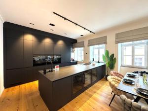 a kitchen with black cabinets and a table in a room at NAMASTÉ Homes - Luxus-Apartment mit Whirlpool & Garage in Bad Windsheim