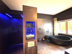 a bathroom with a black tub in a room at NAMASTÉ Homes - Luxus-Apartment mit Whirlpool & Garage in Bad Windsheim +15 photos