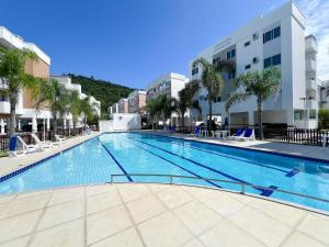 a large swimming pool in the middle of a building at Apê com A/C, Garagem e Piscina em Canasvieiras in Florianópolis