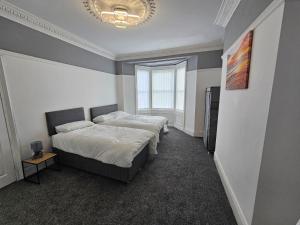 ElswickにあるFamily b&bのベッド2台とシャンデリアのある寝室