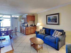 a living room with a blue couch and a kitchen at Ocean Jewels Club 319 in Daytona Beach