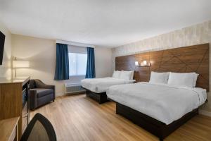 ウェスト・スプリングフィールドにあるBaldwin Inn & Suites, SureStay Collection by Best Westernのベッド2台とテレビがあるホテルの部屋