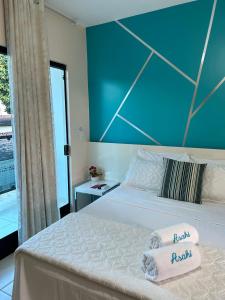 a bedroom with a bed with a blue wall at Pousada Asahi in Porto De Galinhas +22 photos