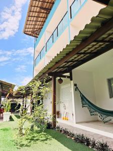 a house with a hammock on the side of it at Pousada Asahi in Porto De Galinhas