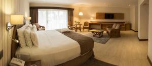 a hotel room with a large bed and a living room at Hotel Camino Real in Santa Cruz de la Sierra +76 photos