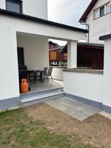 a white house with a patio with a table at White Quenn Apartments in Sanski most