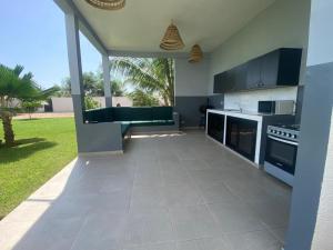 a kitchen with black and white appliances and a yard at Villa d'exception piscine à débordement jardin tropical in Mbour
