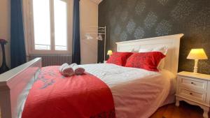 a bedroom with a large bed with red pillows at Neyrpic Campus Université in Saint-Martin-dʼHères