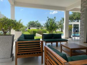 a patio with two couches and a table at Villa d'exception piscine à débordement jardin tropical in Mbour