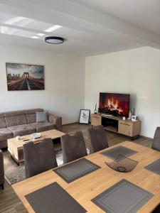 a living room with a couch and a table and a tv at White Quenn Apartments in Sanski most