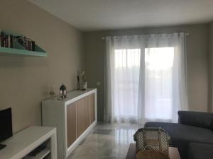Una sala de estar con un sofá y una ventana. en El Rincón de la Siesta, en La Cala de Mijas