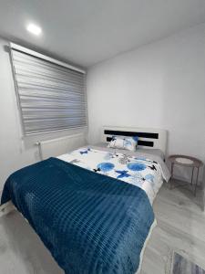 ein Schlafzimmer mit einem Bett mit einer blauen Decke in der Unterkunft Sunset Delux Apartment in Visoko