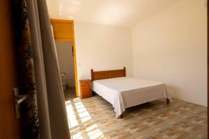 a bedroom with a white bed and a wooden floor at Hope Villa in Calodyne +6 photos