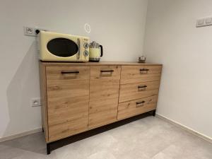 a microwave sitting on top of a wooden dresser at Monstera III - industrial in Kolín