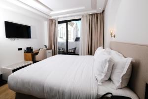 a hotel room with a white bed and a window at Chic Hotel in Rabat