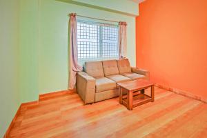 ein Wohnzimmer mit Sofa und Tisch in der Unterkunft Hotel O Sri Sai Guru Comforts in Bangalore