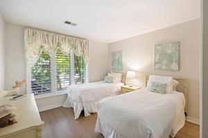 two beds in a room with a window at IC50: 50 Inlet Cove in Kiawah Island +55 photos