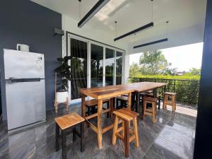 a kitchen with a wooden table and chairs and a refrigerator at ฟ้ารีสอร์ต FAH Resort in Ban Nong Khang