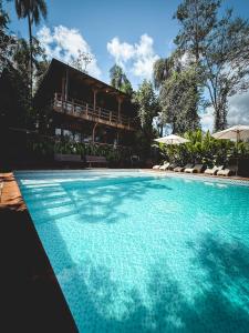 a swimming pool in front of a house at GLAMPING SELVA IGUAZU in Puerto Iguazú