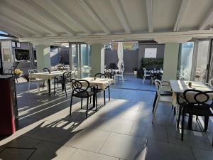 restauracja ze stołami i krzesłami na patio w obiekcie Affittacamere cosulich w mieście Monfalcone