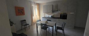 a kitchen with a table and chairs in a room at Short Location Paratore Casa Melina in Catania