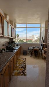 a large kitchen with a large window and a table at city centre house Near to souk Elhad agadir in Agadir