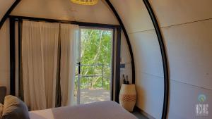 a bedroom with a mirror and a door to a patio at GLAMPING SELVA IGUAZU in Puerto Iguazú +81 photos