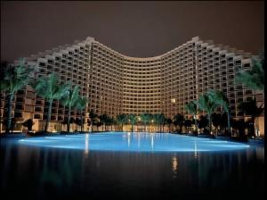 a large building with palm trees in front of it at The Arena Resort Beach Front View LightA-0441 in Cam Ranh International Airport