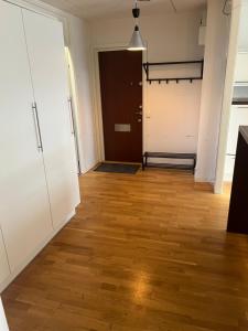 an empty room with a door and wooden floors at Lägenhet i Stockholm in Märsta