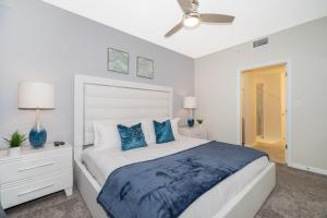 Un dormitorio con una cama grande con almohadas azules. en 3111-102RD CONDO 2 BEDS/2 BATHS (SANITIZED), en Kissimmee 23 fotos más