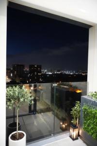 a balcony with a view of a city at night at E1 Suites - Modern Comfort & Spa Luxury, Gibraltar in Gibraltar
