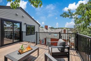 a deck with a table and chairs on a house at Entire House Free Parking Sleeps 26 MIT Harvard TD in Somerville