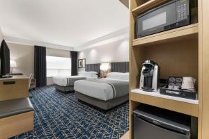 a hotel room with two beds and a flat screen tv at Best Western Premier Route 97 Vernon in Vernon +54 photos