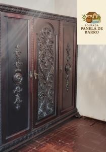 a pair of wooden doors on a wall at Hotel Pousada & day use Panela de barro in Barra Bonita