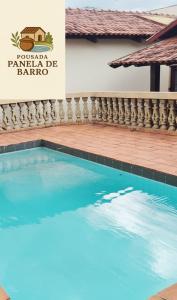 a swimming pool with a sign that reads pocomoke barbecue barrio at Hotel Pousada & day use Panela de barro in Barra Bonita