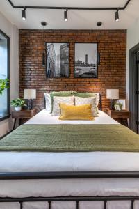 a bedroom with a large bed with a brick wall at Entire House Free Parking Sleeps 26 MIT Harvard TD in Somerville
