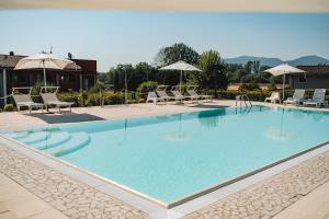 a large swimming pool with chairs and umbrellas at Hotel Carignano in Lucca