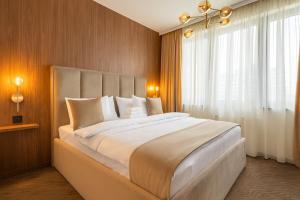 a bedroom with a large white bed with a window at Belgrade Waterfront Luxury Studio in Belgrade