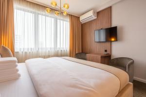 a hotel room with a bed and a flat screen tv at Belgrade Waterfront Luxury Studio in Belgrade
