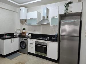 a kitchen with a stainless steel refrigerator and a stove at Joli appartement Mohammédia in Mohammedia