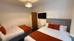 a hotel room with two beds and a flat screen tv at Saint Paul 01 in Bristol