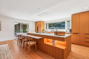 Una cocina con muebles de madera y una barra con taburetes. en Evergreen Stowe, en Stowe