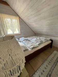 KrynkiにあるOzierański Eden "Pod rzeźbami"の窓のある小さな部屋のベッド