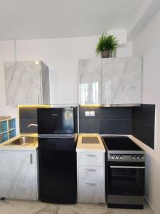a kitchen with a black refrigerator and a sink at Valaoritou Luxury Jacuzzi by Dimcol 1 in Thessaloniki