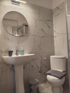 a bathroom with a sink and a toilet and a mirror at Valaoritou Luxury Jacuzzi by Dimcol 1 in Thessaloniki +9 photos